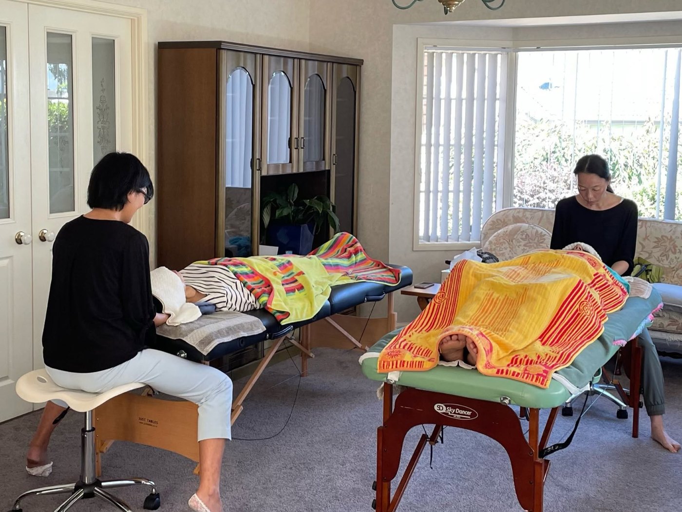 Two therapists giving treatments in a home salon